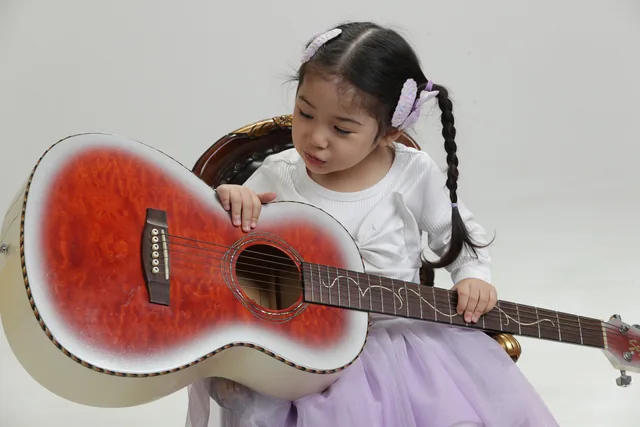 기타 줄을 만지며 즐거워하는 일린의 스튜디오 사진